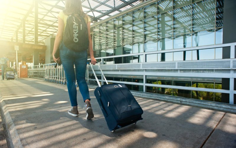 A women with backpack carrying her luggage.