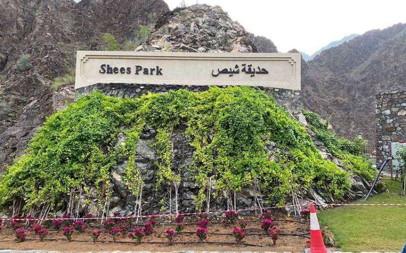 Shees park written on a white marble with huge mountains aside.