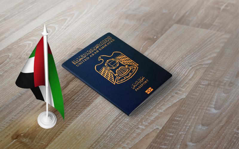 Passport of United Arab Emirates with national flag on the top of an wooden background